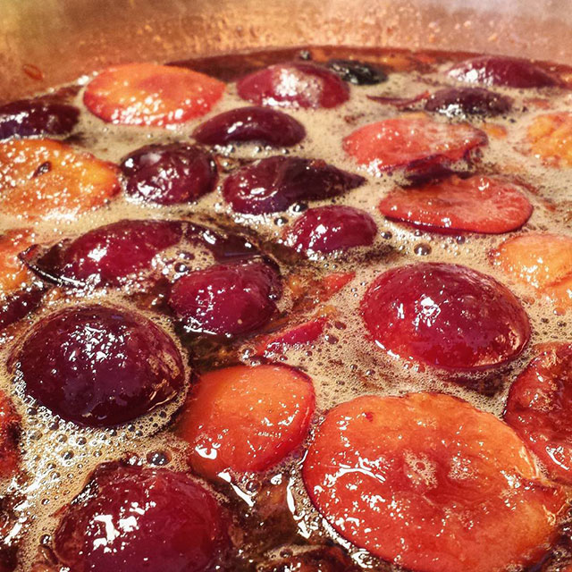 Plums warming in a copper pan