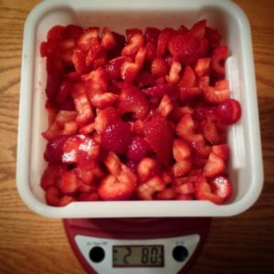 Strawberries have been hulled, chopped, and weighed.