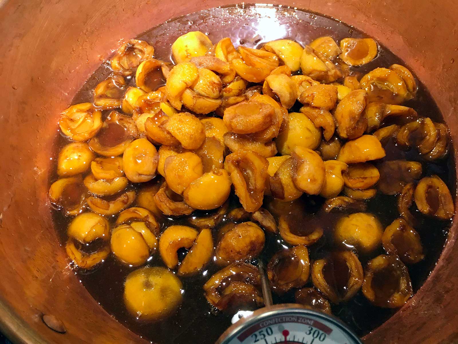 Loquats cooking in a copper pan