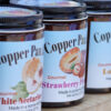 Jars of Copper Pan Jams displayed on butcher block